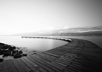 Image of dock going out into lake with mountains in the background