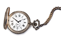 brass pocket watch against a white background
