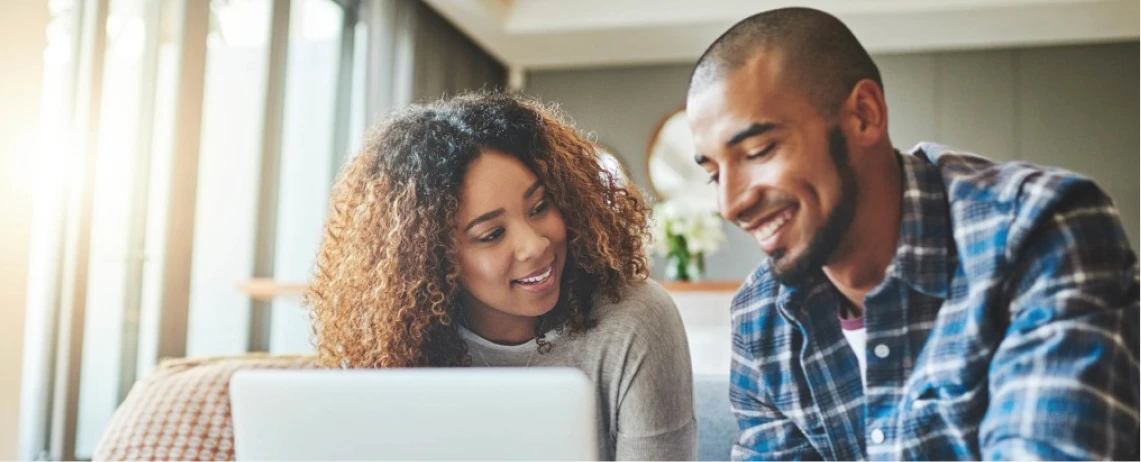 Two people at home looking at a laptop