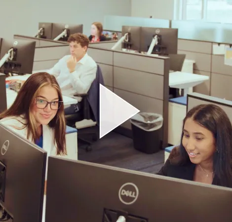 Two interns looking at screen in office