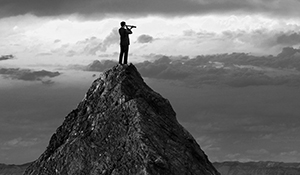 Man on Mountaintop looking through a telescope