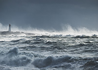 Image of rough seas with a lighthouse on the shore in the background